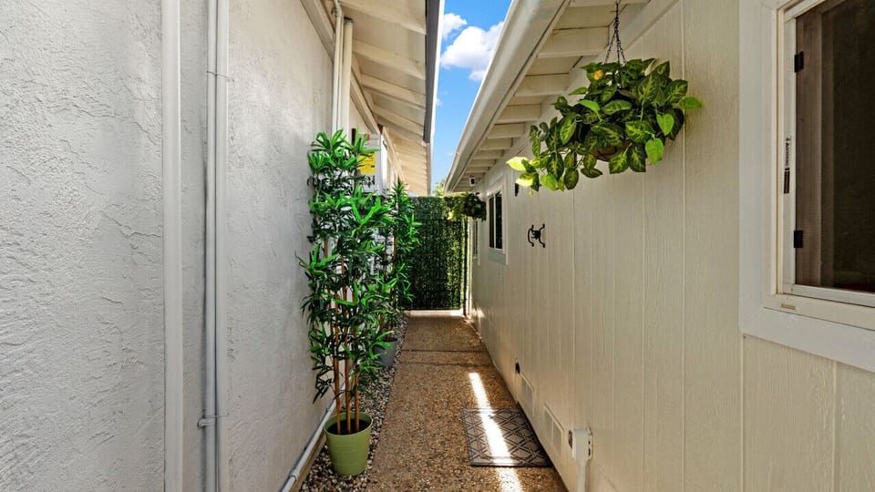 Charming walkway adorned with lush plants – a welcoming path to your private retreat!