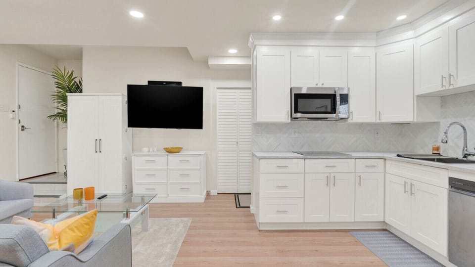 Fully-equipped kitchen with modern appliances and a sleek design – perfect for cooking at home! Relax in the cozy living area with a large TV for your entertainment.