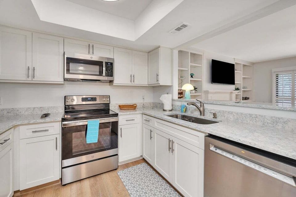 Kitchen with white cabinets, granite counters, and stainless appliances