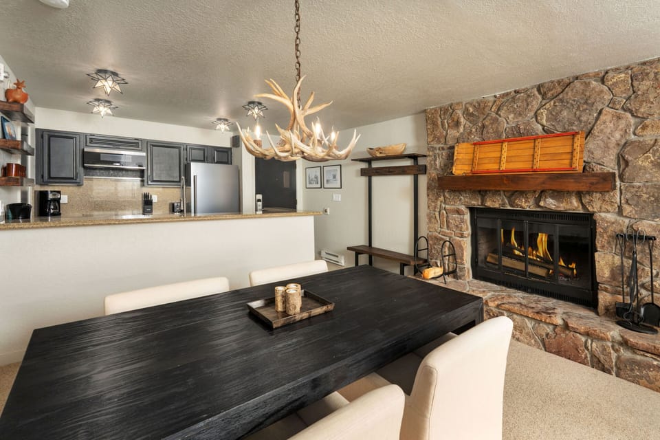 Gather around the rustic antler chandelier and crackling fireplace, where your mountain getaway memories will be made over home-cooked meals in this inviting open-concept space.