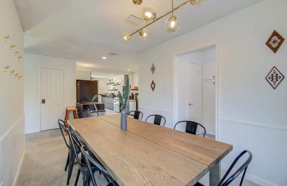 Perfect for sharing meals together, this dining room is designed for connection with a rustic wooden dinner table and eight industrial-style chairs.