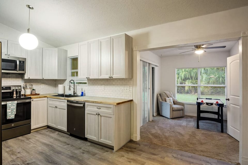 Modern kitchen with stainless appliances and essentials for cooking, prepping, and hosting with ease.