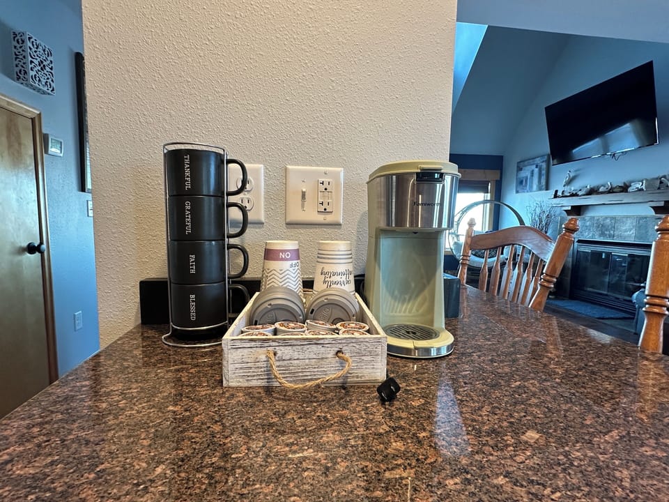 Cozy coffee station, featuring a K-Cup coffee maker and a selection of pods to get you started. 