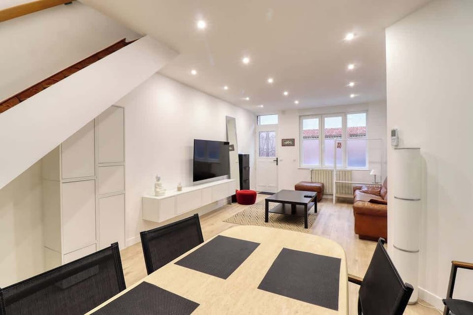 Grand salon avec TV HD connectée et espace salle à manger.
Cuisine ouverte sur la salle à manger (en enfilade).
Accès à la cours privative depuis la salle à manger.