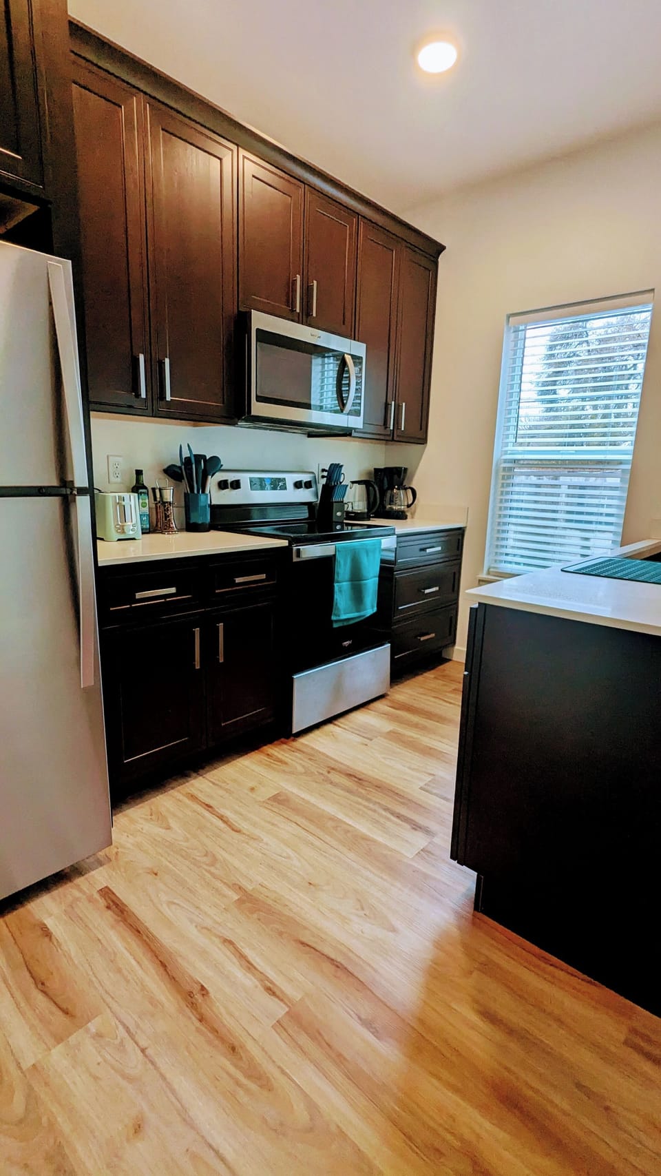 Full kitchen with Whirlpool appliances, drip coffee maker, blender, pots, pans.