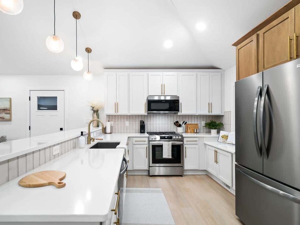 Clean white kitchen w/ island seating, stainless appliances & plenty of counter space