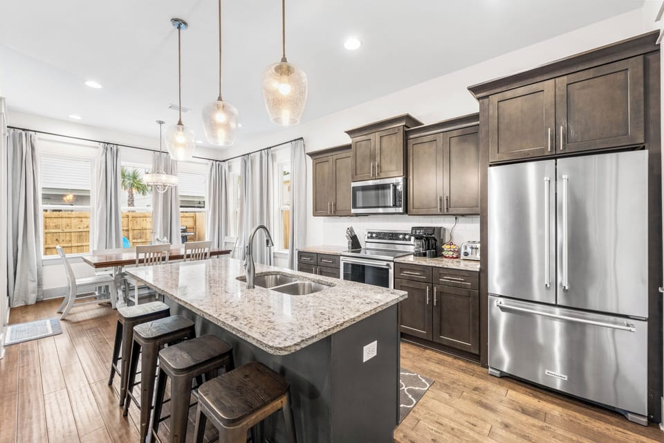 Cook like a chef in this fully stocked kitchen with KitchenAid stainless steel appliances, granite countertops, & island seating for 4