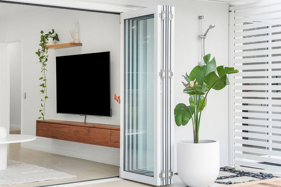 Bifold doors for seamless flow inside and out. Outdoor shower.