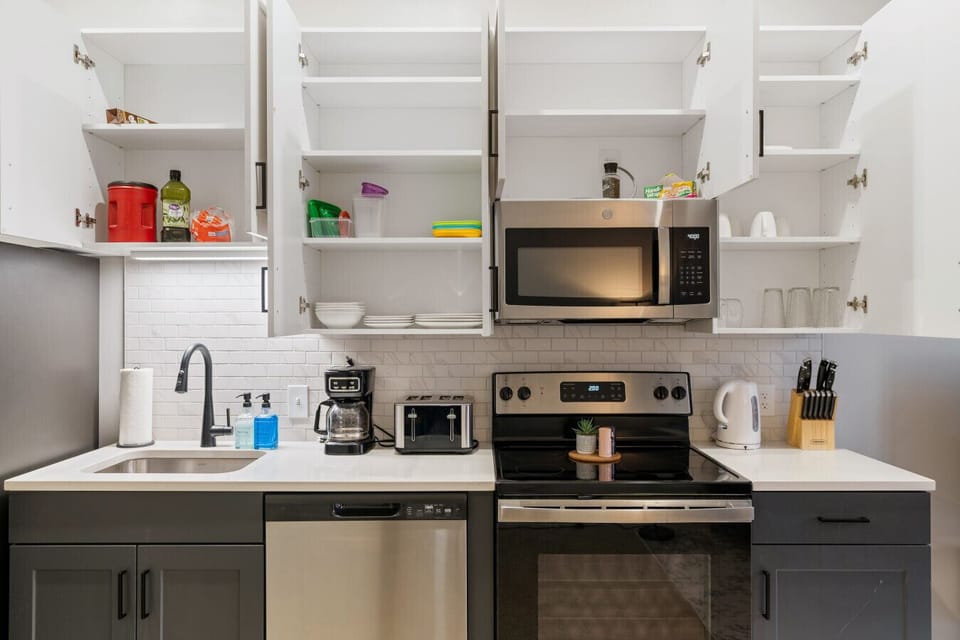 Cook with ease in this well-equipped kitchen featuring stainless steel appliances, ample cabinetry, and a stylish backsplash. Whether you're brewing coffee or preparing a gourmet meal, this space is designed for functionality and style, making every meal
