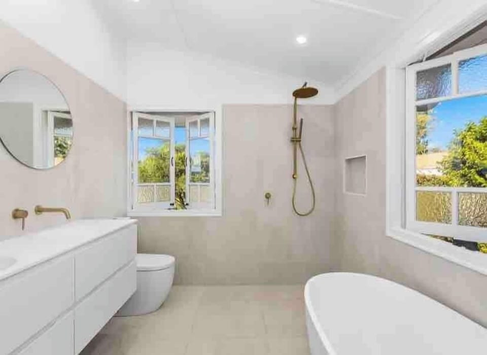 Main bathroom with walk-in rain shower, freestanding bath and brass tapware