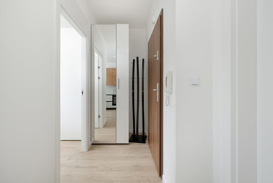 A compact corridor leading to the bedroom and kitchen. Clean white walls enhance the sense of space.