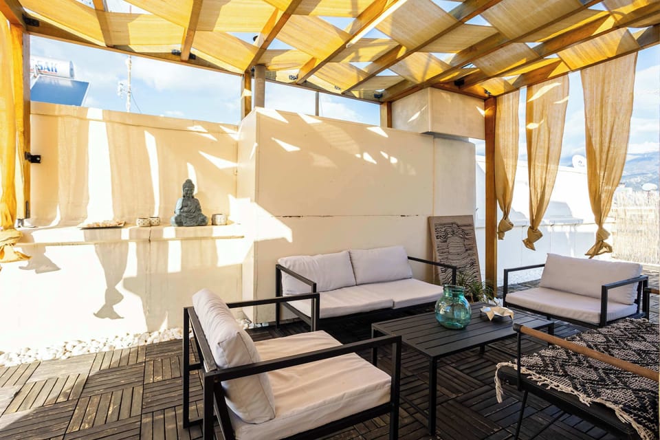 Outdoor Dining Area with Pergola Shade, Dining Table, and Decorative Curtains

