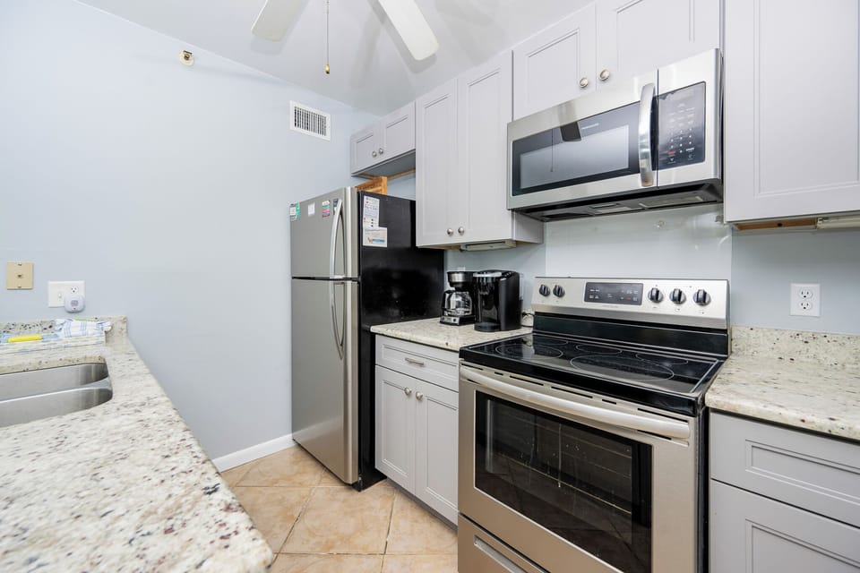 The kitchen features stainless steel appliances, granite countertops, and a coffee maker for a delightful cooking experience