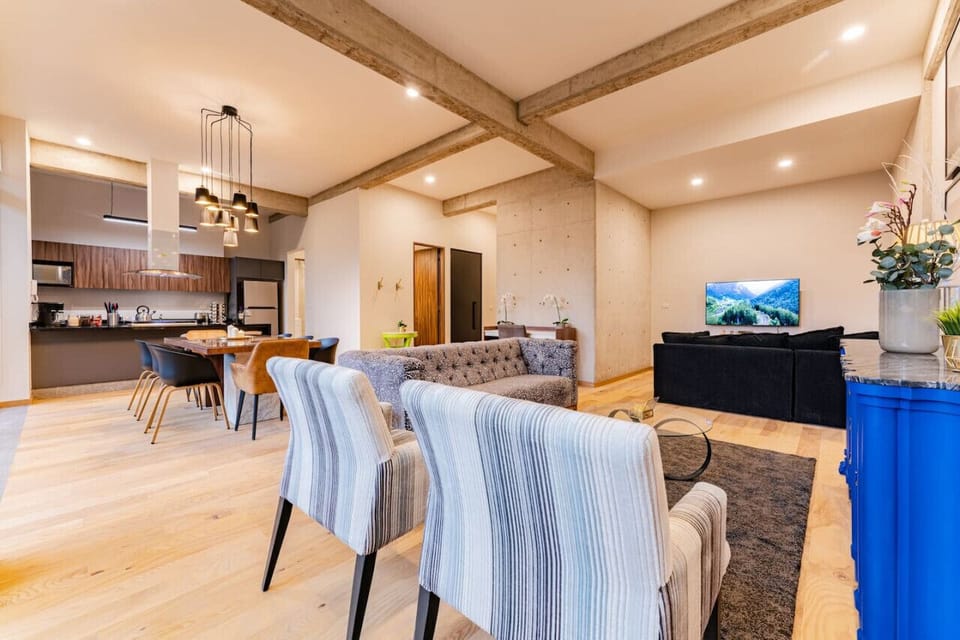 Spacious and airy dining and living room area, bathed in natural light from large windows.