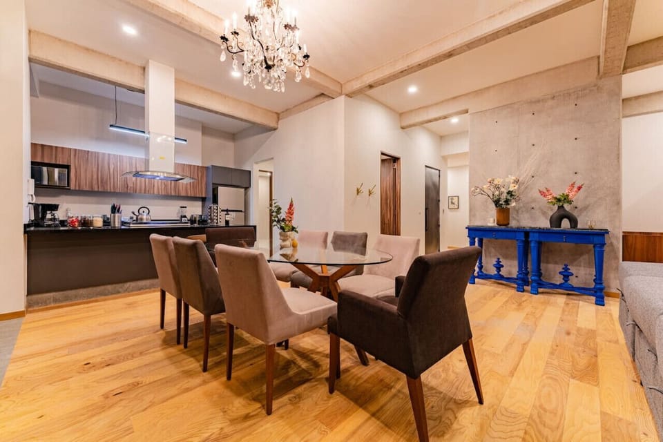 Open dining space with seating for eight, overlooking lush outdoor greenery.