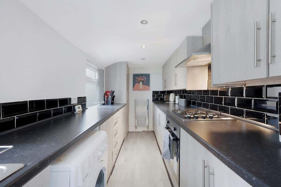 Kitchen equipped with all essentials, including a microwave, oven, toaster, kettle, fridge and full cookware set.