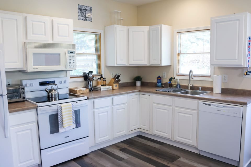 The kitchen area is open and spacious with a refrigerator, electric stove, dishwasher, microwave and toaster.     