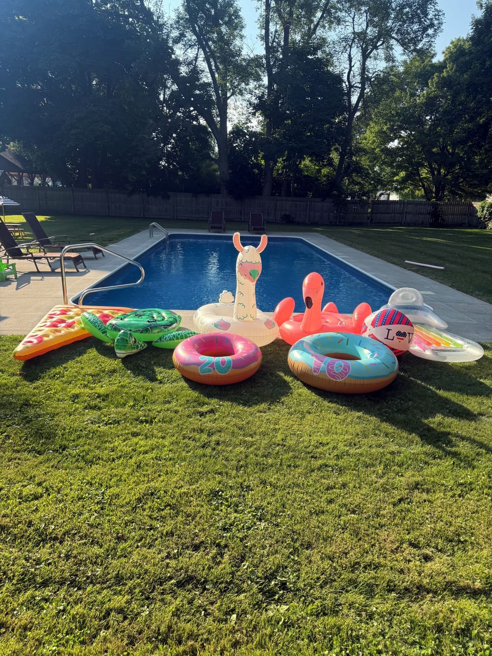 Pool supplied with plenty of floaties and lounge chairs 