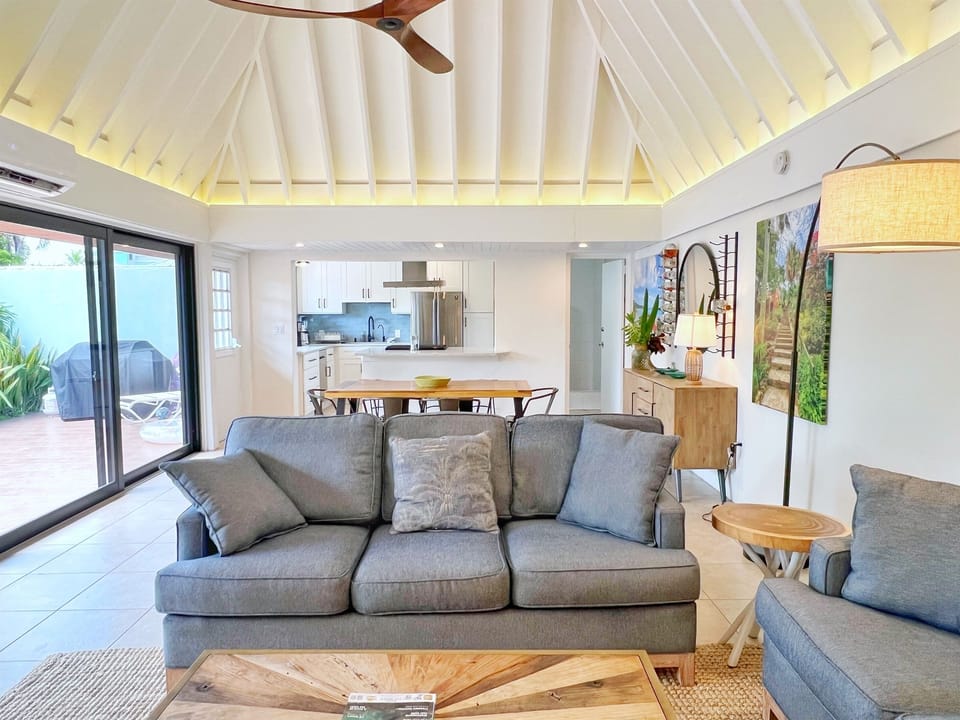 Stylish wooden tables and bright coastal décor complete this inviting living room.