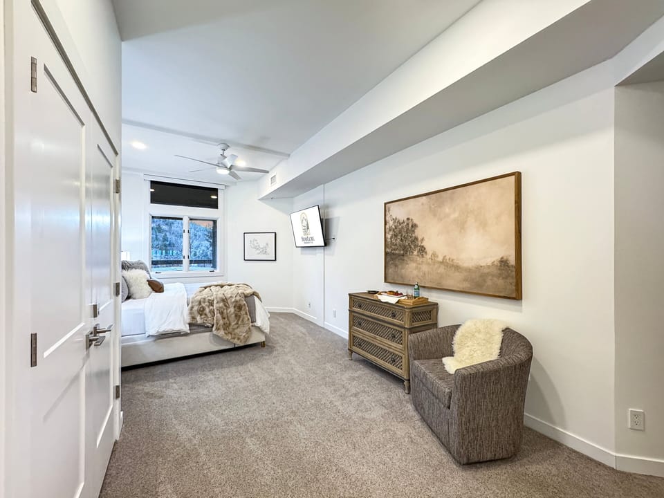 The master bedroom is spacious and features a chair to sit and read a book or put your shoes on.