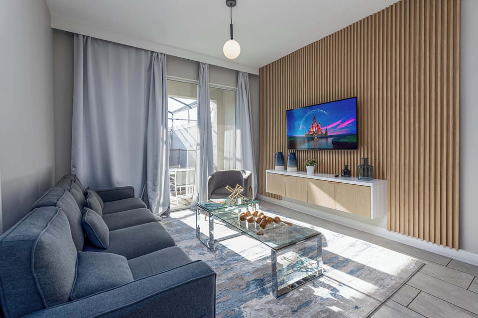 Modern living room with plush seating and a large smart TV.