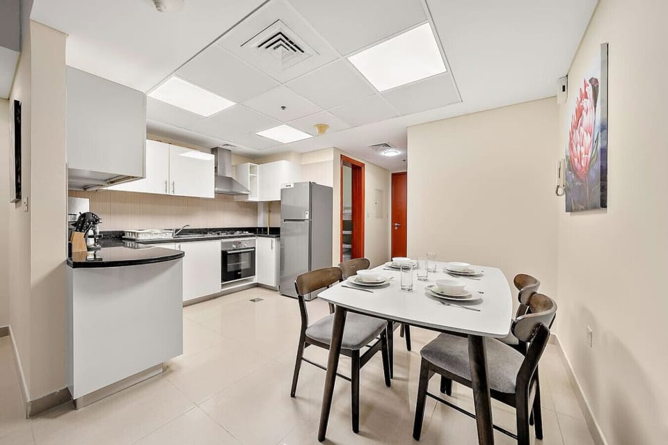 Open kitchen and dining area with modern appliances and four-seat table.