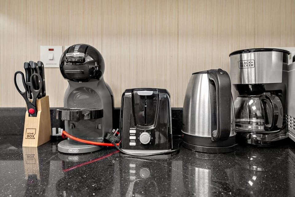 Countertop with coffee machine, toaster, kettle, and knife set neatly arranged.