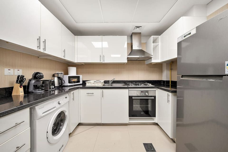 Modern kitchen with appliances, white cabinets, and integrated washing machine.