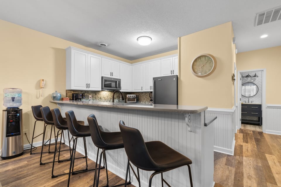 Gather around the spacious kitchen island where six bar stools invite you to enjoy morning coffee or evening conversations together.