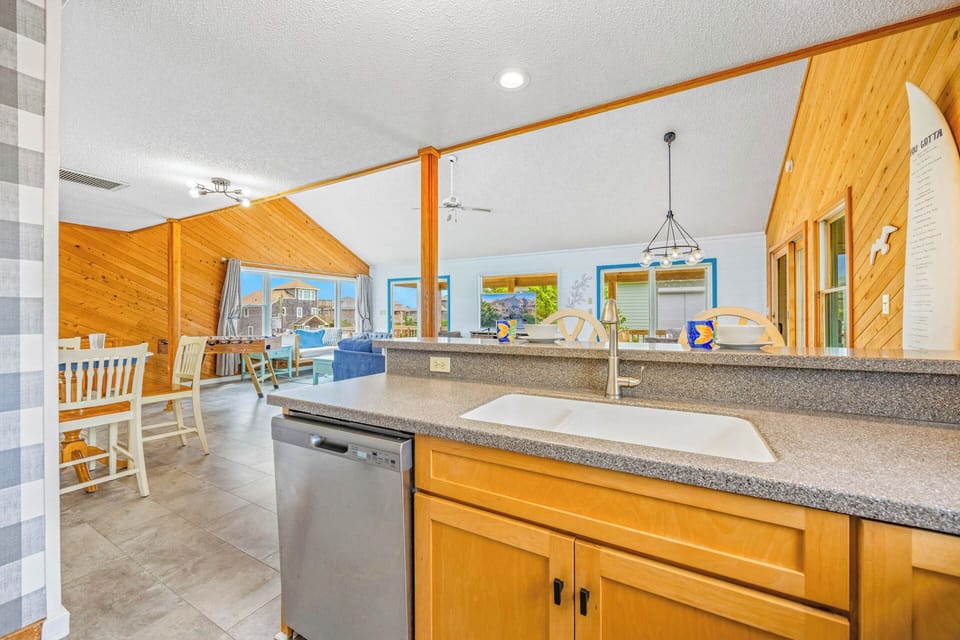 Step into this bright, open-concept retreat where warm wood tones and coastal colors create your perfect beach getaway. The fully-equipped kitchen flows seamlessly into your dining and living spaces, all bathed in natural light.