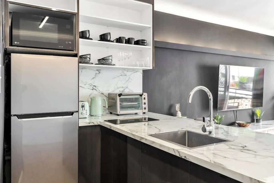 Prepare your meals in the stylish kitchen, fully equipped with modern appliances and sleek marble countertops.