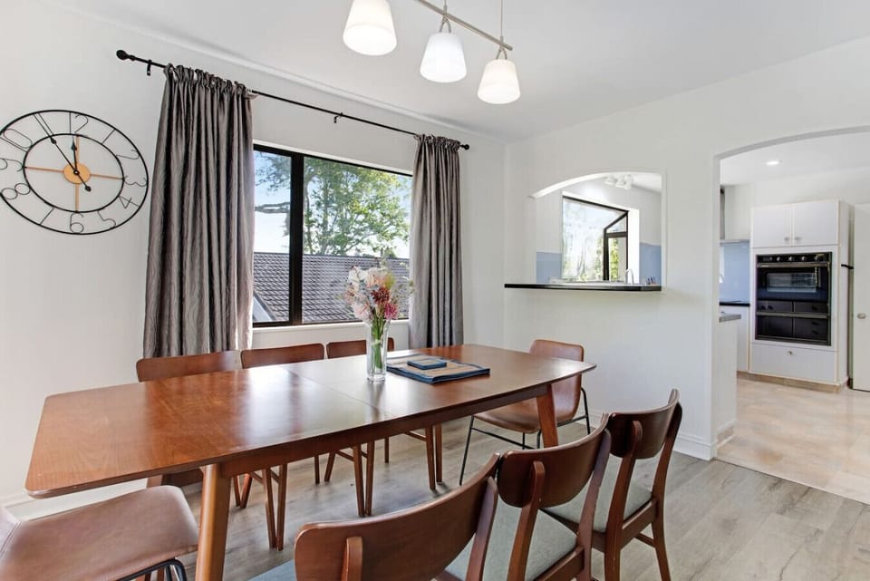 The dining room has a wooden table surrounded by matching wooden chairs.