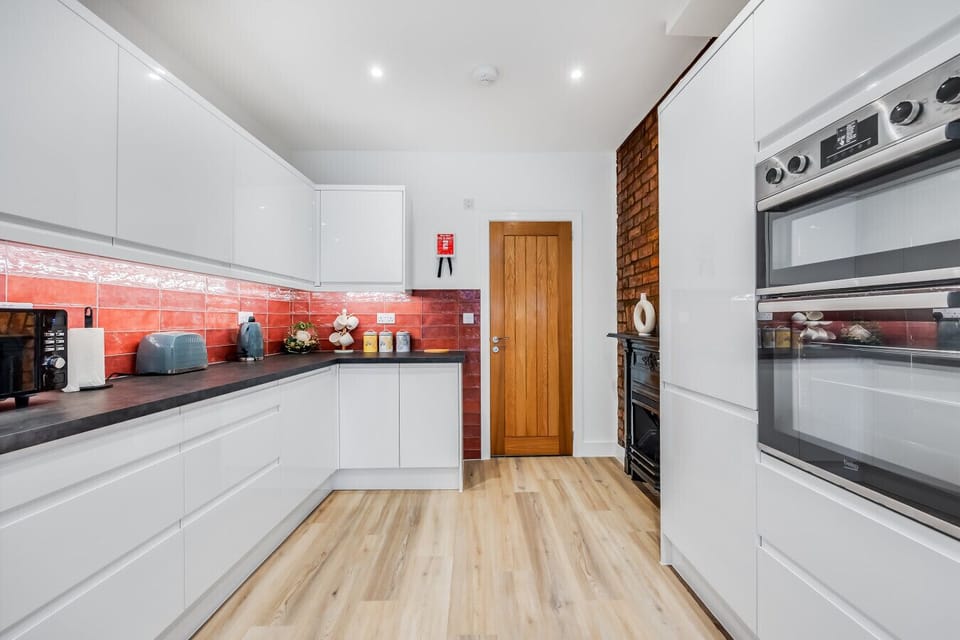 A fully equipped kitchen with a fridge freezer, oven, stove, microwave, dishwasher, kettle, toaster, cookware, tableware, and utensils all provided