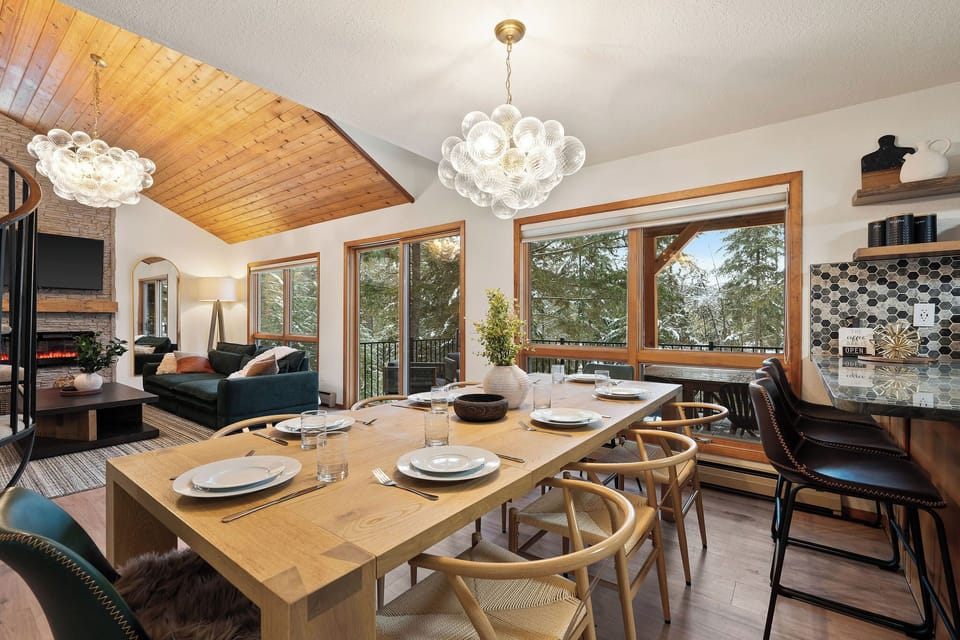 The dining table accommodates 8. There are 4 bar stools for seating at the bar.