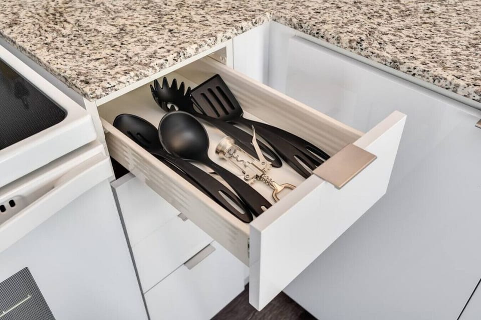 Kitchen cabinets stocked with cooking wares, glassware and silverwares, ideal for mixing up your favorite meals and drinks during your stay.