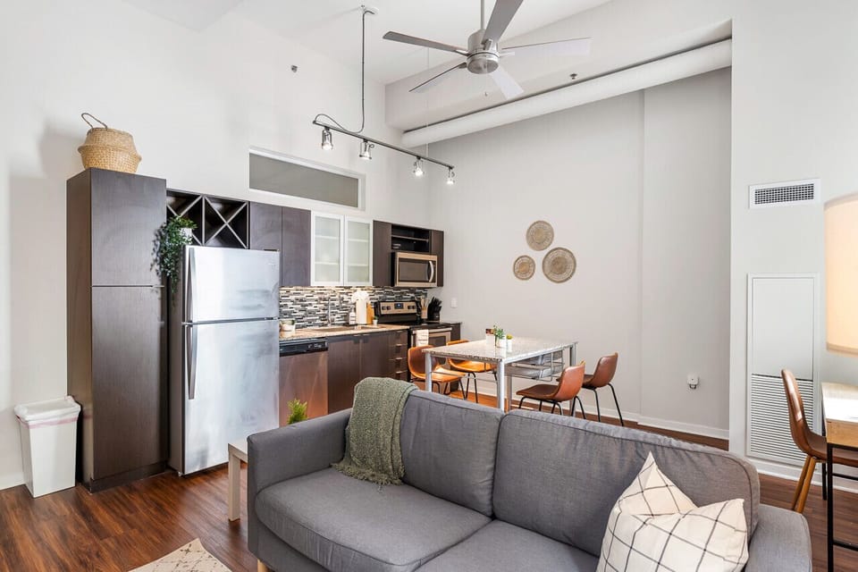 The living room’s plush seating beckons you to sink in and relax, surrounded by light and airy decor.