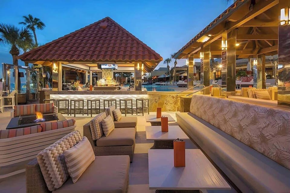 Outdoor lounge area with bar and access to steps to the beach