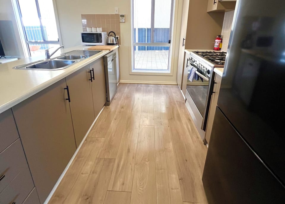 The full-sized kitchen includes modern appliances, ample bench space, and everything needed to prepare family meals