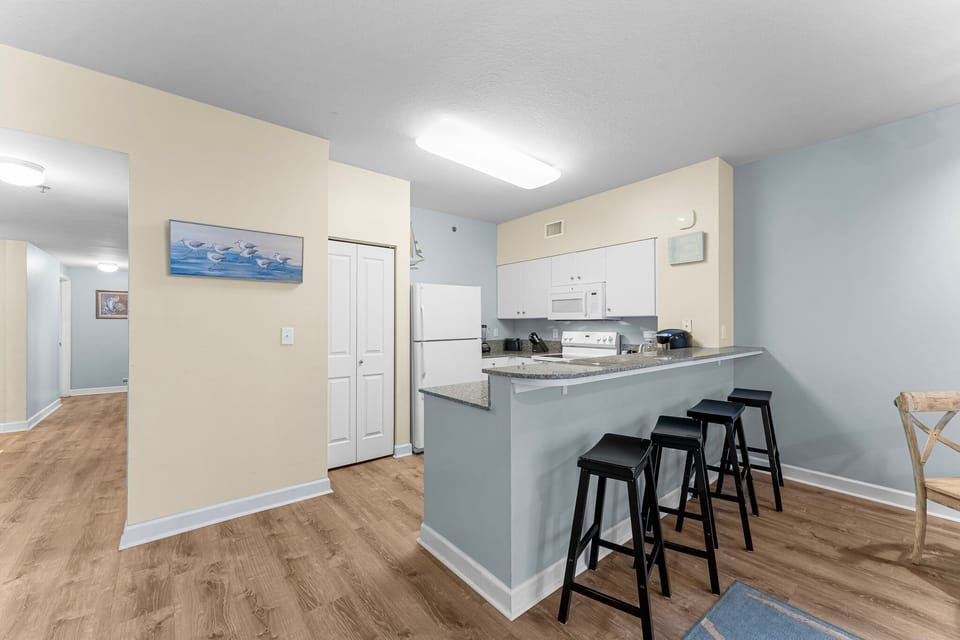 Modern kitchen with breakfast bar and seating for three.