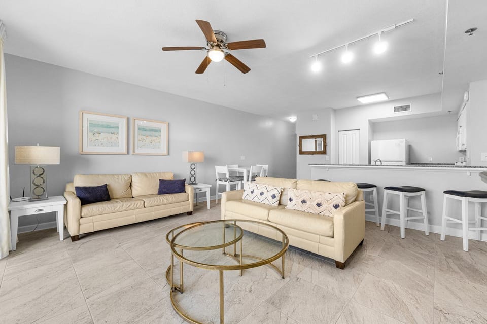 spacious living area with modern beige sofas and a glass coffee table