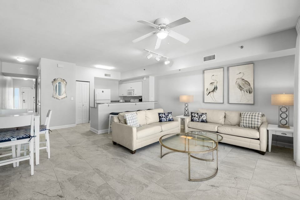 Open-concept living area with modern furnishings and coastal artwork.