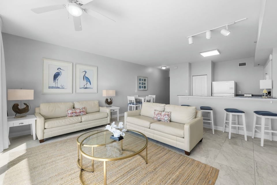 Modern living room with comfortable seating and an open kitchen bar area.