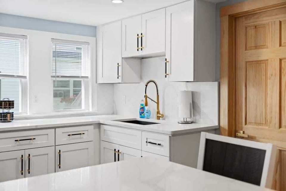 This kitchen is filled with natural light and features a spacious sink, making it both beautiful and functional.