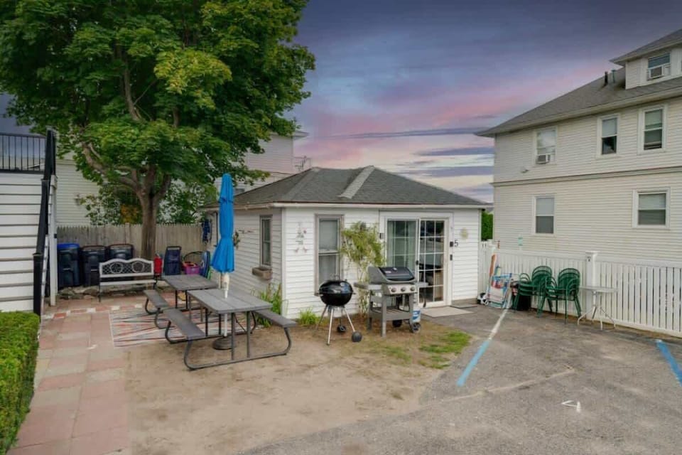 Spacious outdoor area with picnic tables and a grill, ideal for enjoying meals and relaxing after a day at the beach.