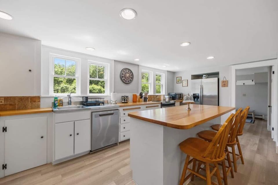 Prepare delicious meals in the fully stocked kitchen, featuring a butcher block island, stainless steel appliances, and all the essentials.