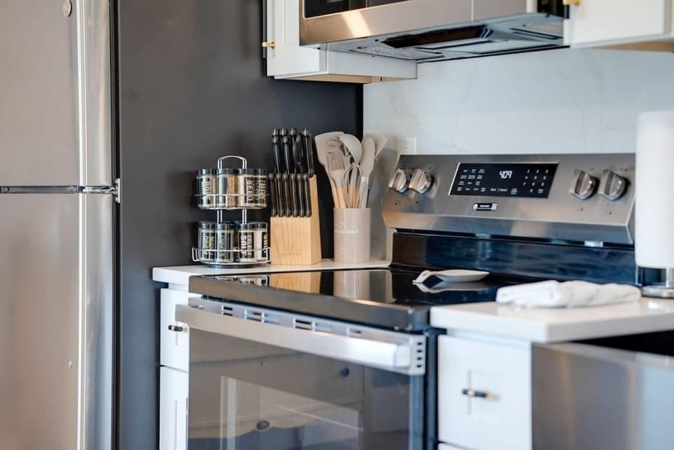 Fully equipped kitchen featuring a modern stove, cooking utensils, and a spice rack to inspire your culinary creations.