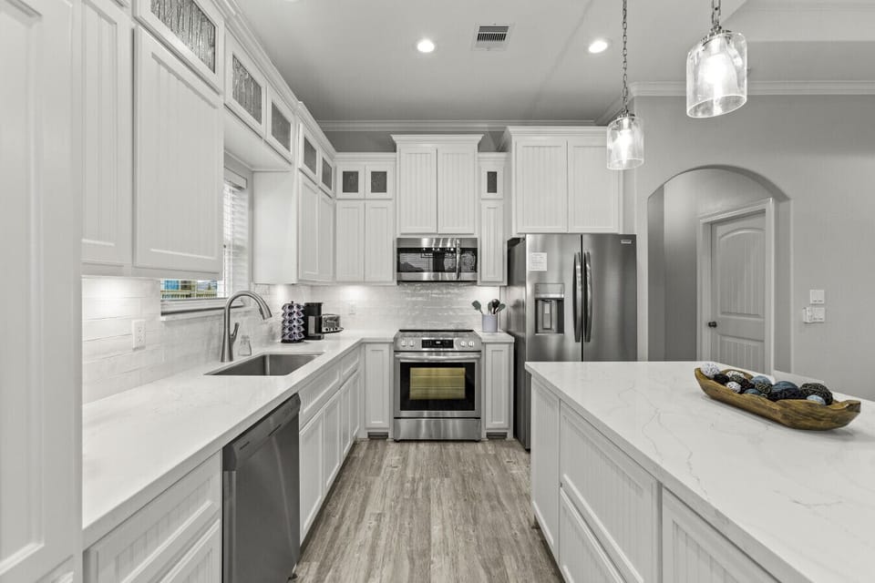 Bright kitchen with quartz counters and modern appliances.
