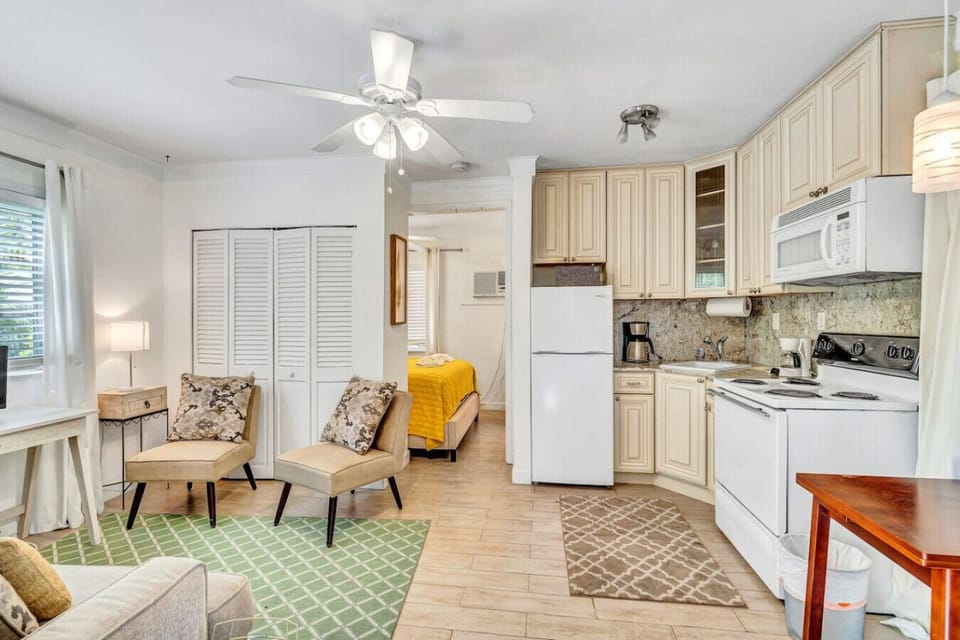 Embrace the charm of this combined kitchen and living room, complete with the gentle hum of a ceiling fan overhead