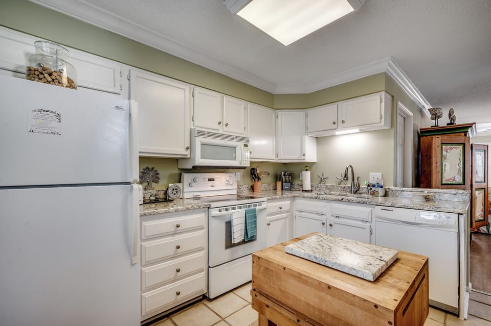 Step into the charming chef’s kitchen with sleek granite countertops, ample storage, and a craft butcher block—perfect for your next culinary creation.