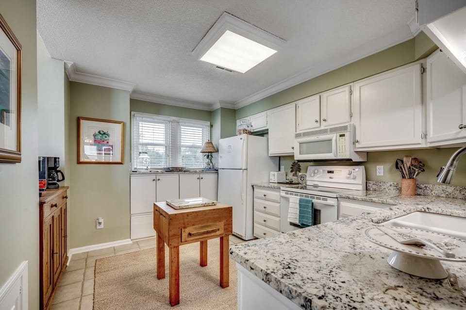 Step into the charming chef’s kitchen with sleek granite countertops, ample storage, and a craft butcher block—perfect for your next culinary creation.